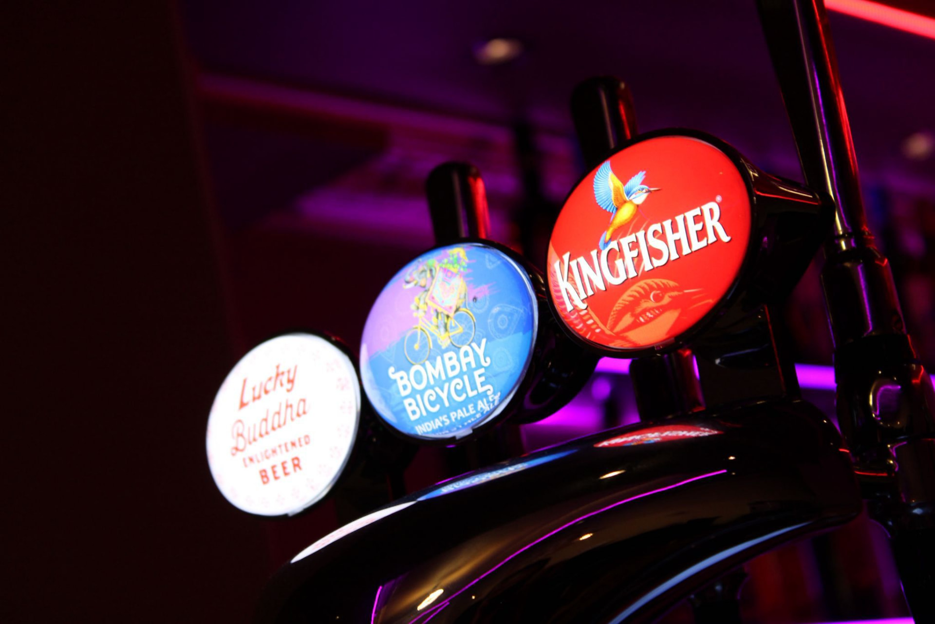 Beer taps lit by the bar's neon glow